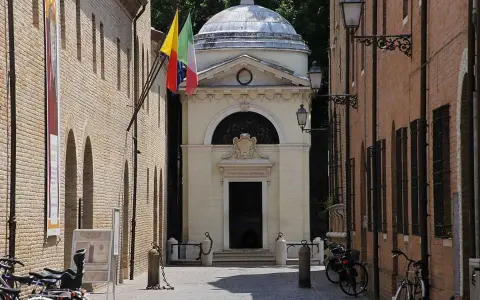 Il Tempio Malatestiano, luogo dove morì Dante Alighieri, con bandiere e biciclette parcheggiate.