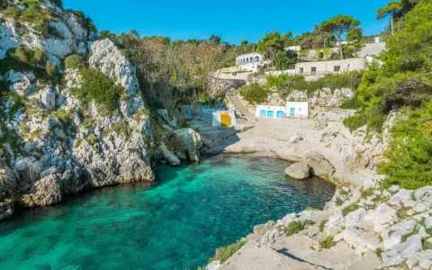 Baia con acque cristalline e case bianche, perfetta per un tour della Puglia in 5 giorni.