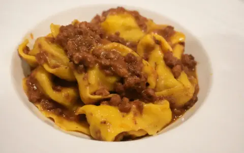 Tortellini fatti in casa con ragù, un classico dei primi piatti romagnoli.