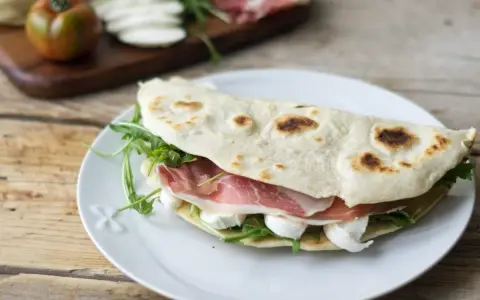 Piadine particolari con prosciutto crudo, mozzarella e rucola, un classico romagnolo pronto per essere gustato.