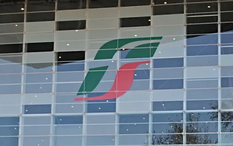 Logo Trenitalia su facciata di vetro. Un'immagine che ricorda il rimborso Trenitalia per ritardi o disservizi.