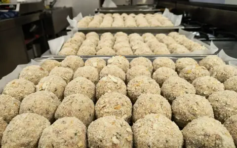 Grandi vassoi pieni di canederli dolci trentini pronti per essere cucinati.