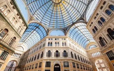 Galleria Umberto I a Napoli, un gioiello architettonico con cupola in vetro. Le differenze con la Galleria Vittorio Emanuele II di Milano sono evidenti nello stile e nei dettagli.