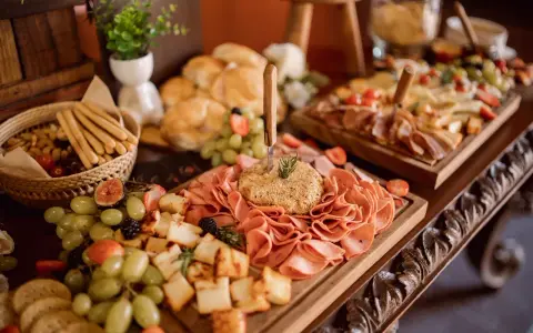 Un ricco buffet con salumi, formaggi, frutta e pane, un vero banchetto che fa pensare alla pensione completa significato: tutto incluso per godersi il momento.