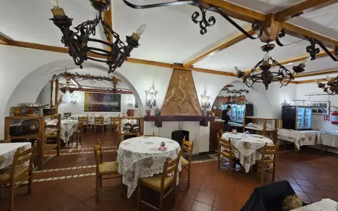 Interno di un ristorante con tavoli apparecchiati e un camino decorato. Un'ottima opzione per sapere dove mangiare a Potenza.