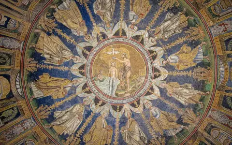 Mosaico circolare con Battesimo di Cristo al centro, circondato da figure di santi e angeli. Un capolavoro da vedere a Ravenna e dintorni.
