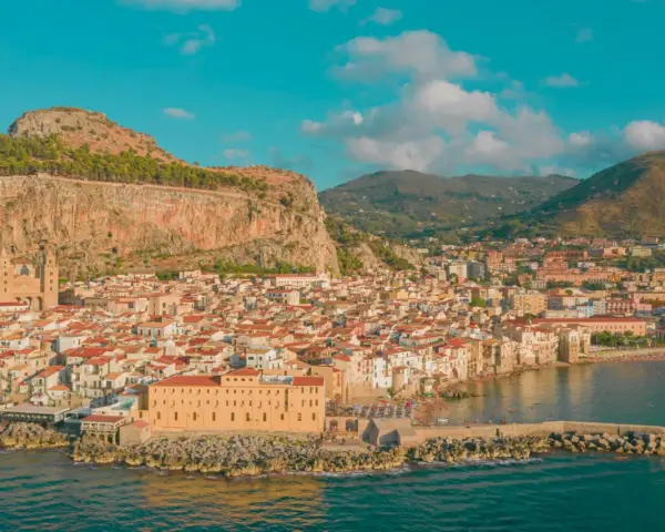 Cefalù, una delle più belle gite di un giorno da Palermo, con il suo borgo arroccato sotto la Rocca e il mare azzurro.