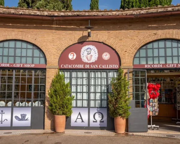 Ingresso alle catacombe di San Callisto, tra i più suggestivi siti di Roma. Due negozi di souvenir fiancheggiano l'entrata principale.