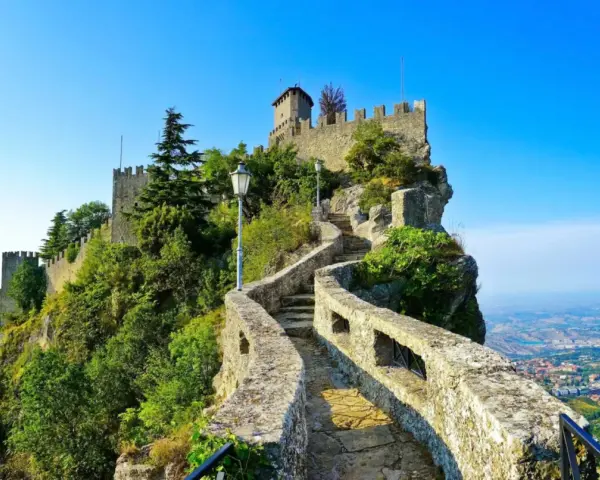 Sentiero roccioso che conduce al castello, noto come il passo delle streghe, con vista panoramica sulla valle sottostante.