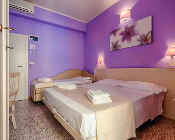 Camera accogliente con letti comodi e pareti viola, ideale per un soggiorno rilassante al Hotel Plaza Gabicce Mare.