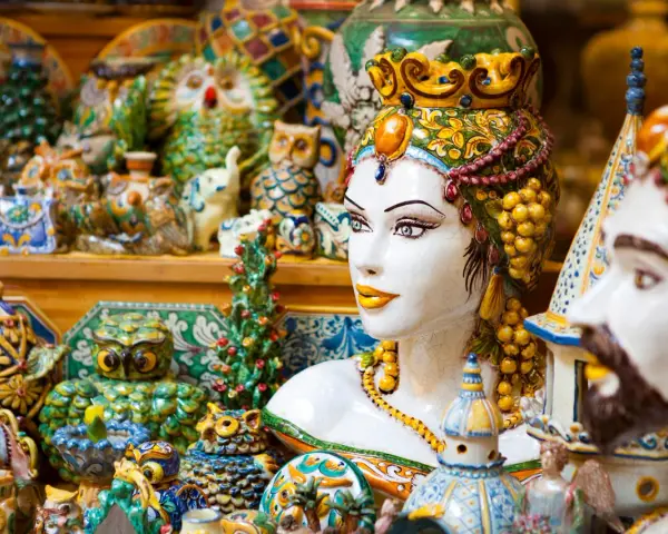 Ceramiche colorate, gufi, teste di moro e vasi: un tripudio di souvenir di viaggio che cattura l'essenza dell'artigianato locale.