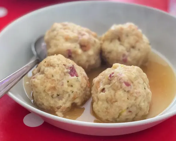 Canederli in brodo, un classico tra i piatti tipici del Trentino Alto Adige, perfetti per scoprire la curiosità culinaria della regione.
