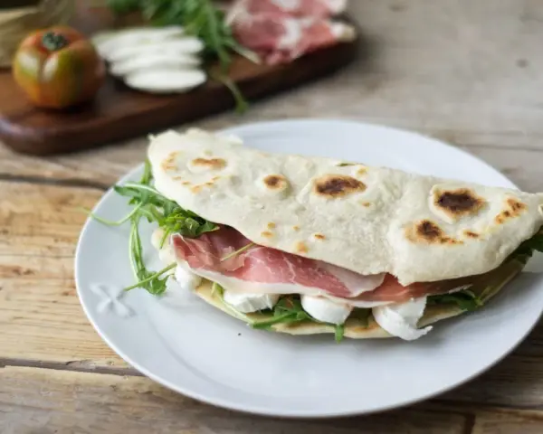 Piadine particolari con prosciutto crudo, mozzarella e rucola, un classico romagnolo pronto per essere gustato.