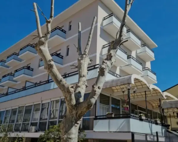 Edificio moderno con balconi e vetrate, un albero spoglio in primo piano. Il **Kursaal Bellaria** si presenta sotto un cielo azzurro.