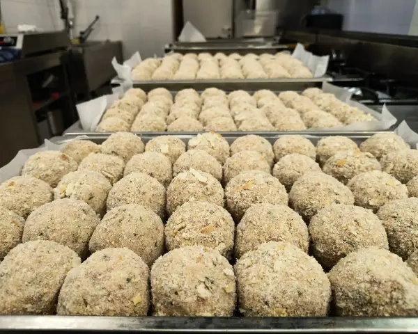 Grandi vassoi pieni di canederli dolci trentini pronti per essere cucinati.