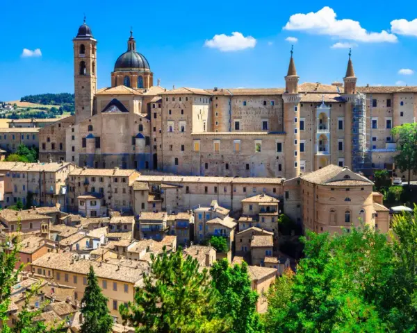 Urbino, con il suo imponente Palazzo Ducale, è un punto strategico per visitare le Marche, offrendo scorci mozzafiato e storia.