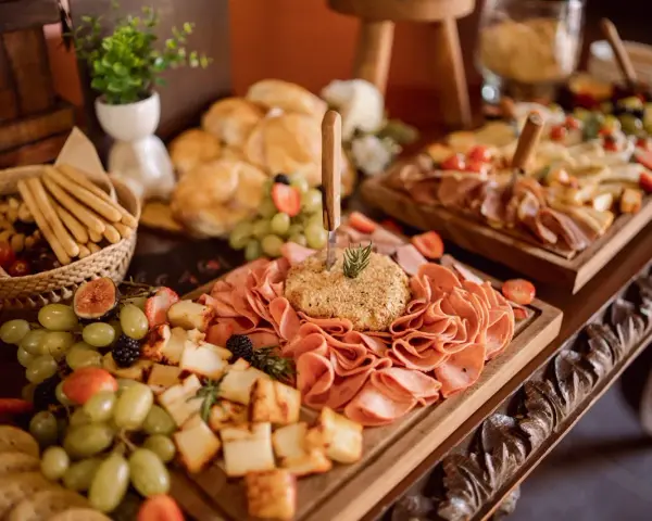 Un ricco buffet con salumi, formaggi, frutta e pane, un vero banchetto che fa pensare alla pensione completa significato: tutto incluso per godersi il momento.