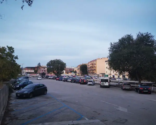 Ampio parcheggio a Matera, con molte auto parcheggiate in file ordinate. Ideale per chi cerca dove parcheggiare a Matera.