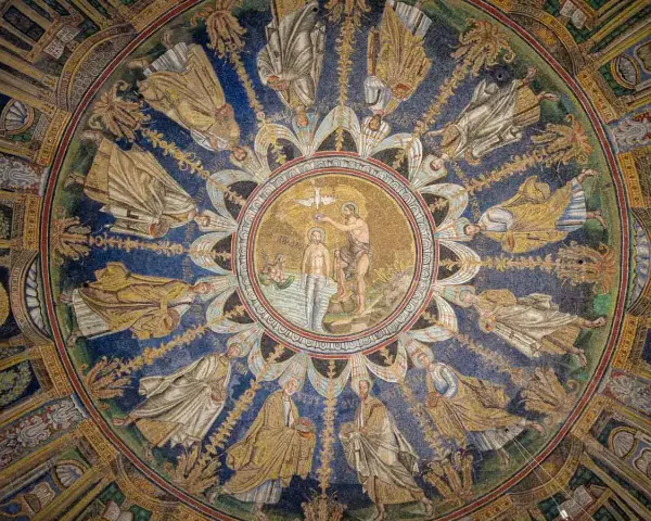 Mosaico circolare con Battesimo di Cristo al centro, circondato da figure di santi e angeli. Un capolavoro da vedere a Ravenna e dintorni.