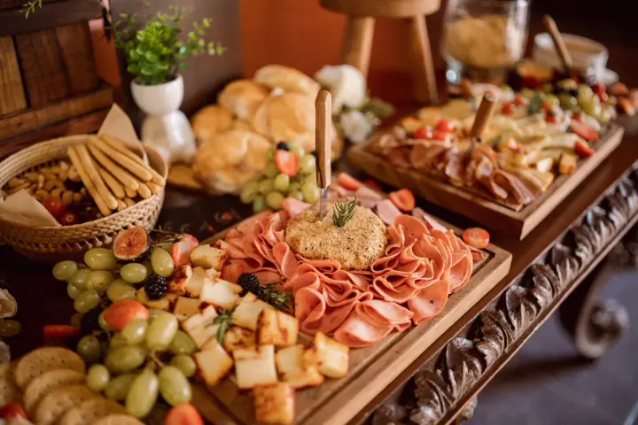 Un ricco buffet con salumi, formaggi, frutta e pane, un vero banchetto che fa pensare alla pensione completa significato: tutto incluso per godersi il momento.