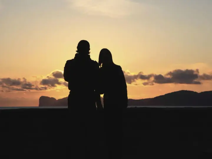 Coppia al tramonto in Sardegna, un'idea perfetta per dove andare in vacanza.