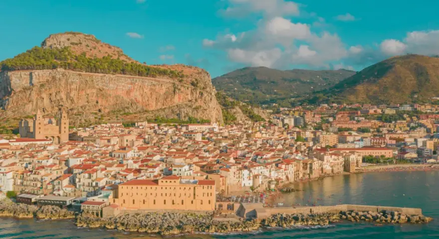 Cefalù, una delle più belle gite di un giorno da Palermo, con il suo borgo arroccato sotto la Rocca e il mare azzurro.