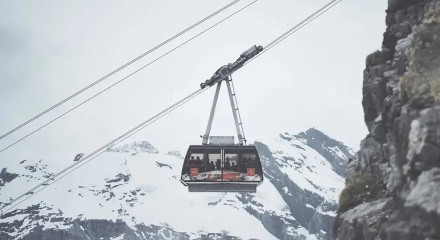Cabina della funivia in Trentino, sospesa tra cime innevate e rocce imponenti, ideale per muoversi in un paesaggio mozzafiato.