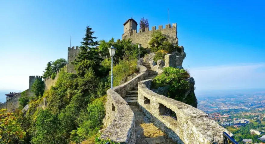 Sentiero roccioso che conduce al castello, noto come il passo delle streghe, con vista panoramica sulla valle sottostante.