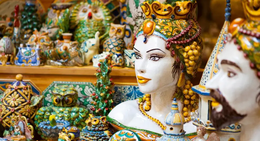 Ceramiche colorate, gufi, teste di moro e vasi: un tripudio di souvenir di viaggio che cattura l'essenza dell'artigianato locale.