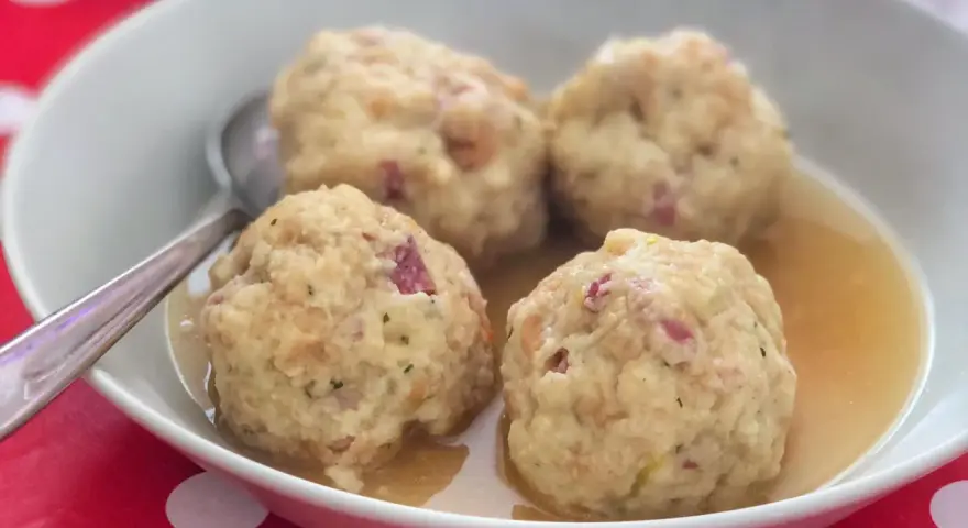 Canederli in brodo, un classico tra i piatti tipici del Trentino Alto Adige, perfetti per scoprire la curiosità culinaria della regione.