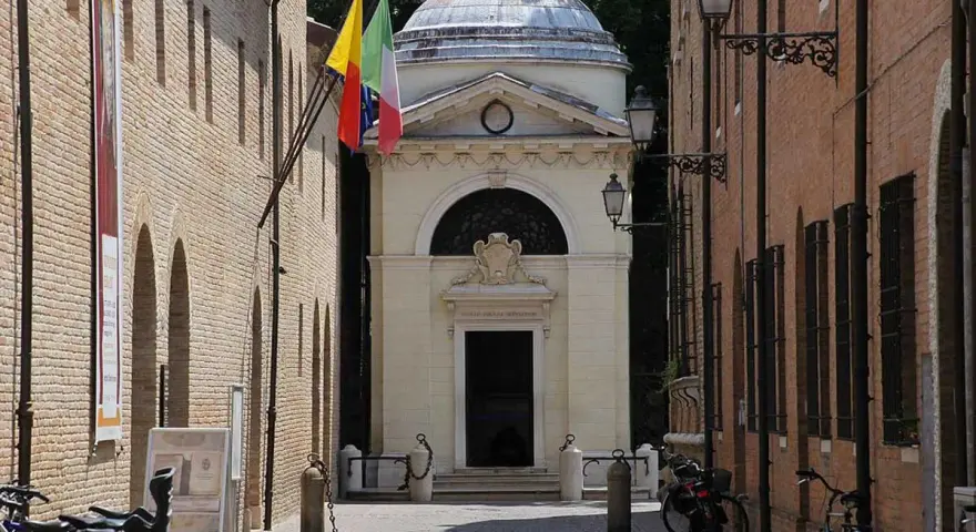 Il Tempio Malatestiano, luogo dove morì Dante Alighieri, con bandiere e biciclette parcheggiate.