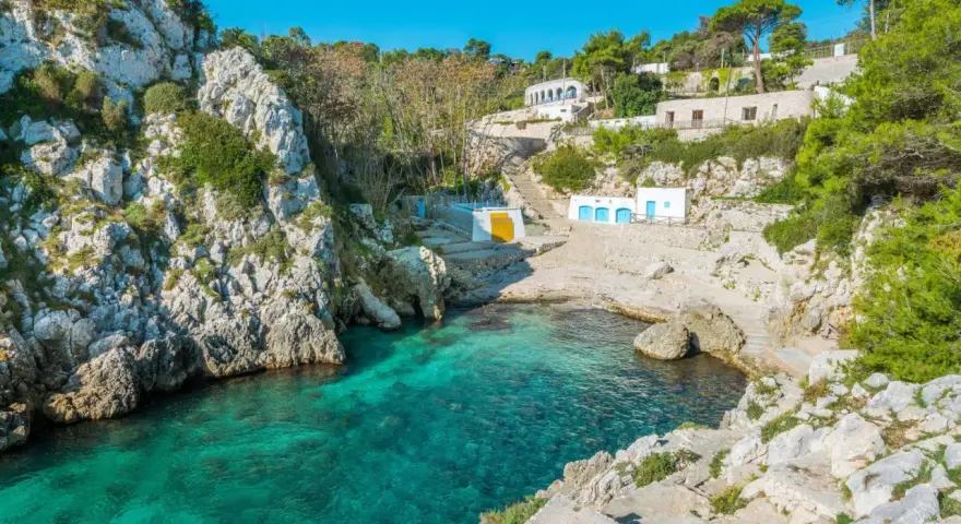 Baia con acque cristalline e case bianche, perfetta per un tour della Puglia in 5 giorni.
