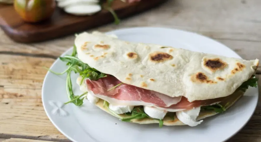 Piadine particolari con prosciutto crudo, mozzarella e rucola, un classico romagnolo pronto per essere gustato.