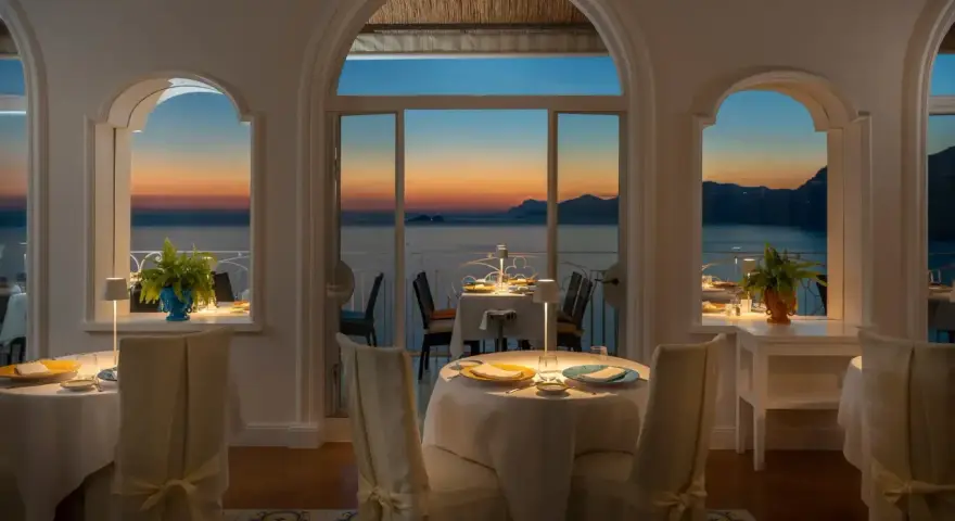 Tavoli apparecchiati nel ristorante dell'hotel Tramonto d'Oro, con vista sul mare al tramonto.