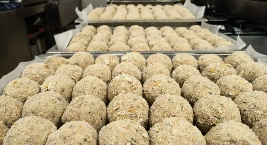 Grandi vassoi pieni di canederli dolci trentini pronti per essere cucinati.