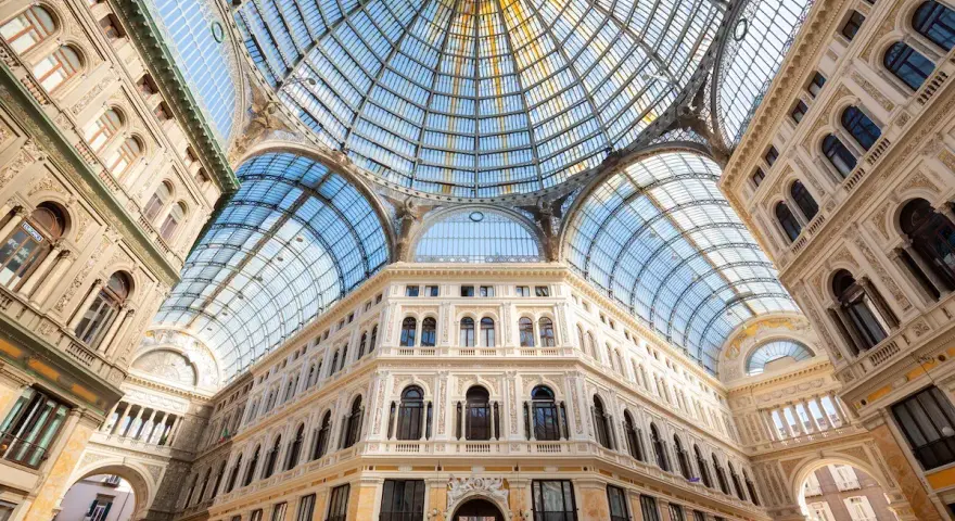 Galleria Umberto I a Napoli, un gioiello architettonico con cupola in vetro. Le differenze con la Galleria Vittorio Emanuele II di Milano sono evidenti nello stile e nei dettagli.