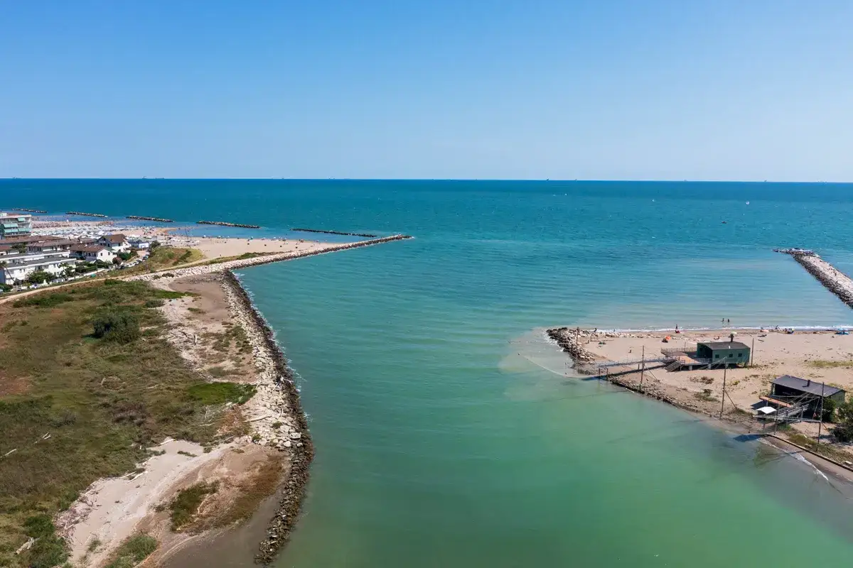 Vista aerea del lido di Savio centro storico con il mare turchese, la spiaggia e le case bianche.
