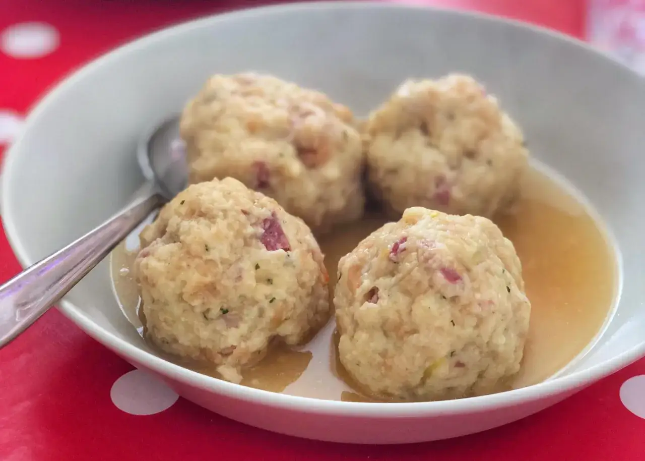 Canederli in brodo, un classico tra i piatti tipici del Trentino Alto Adige, perfetti per scoprire la curiosità culinaria della regione.