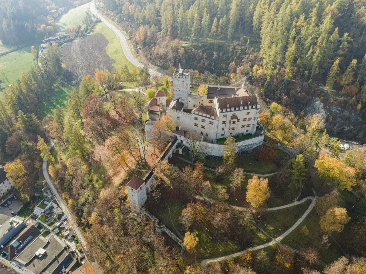 Castello di Brunico in autunno, un luogo incantevole tra le cose da fare a Brunico. Percorsi tra alberi colorati conducono alla fortezza.