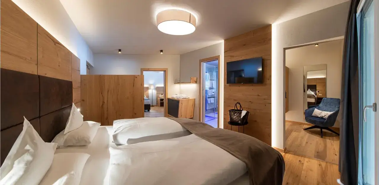 Camera moderna con letto king-size, TV a schermo piatto e bagno in vetro. I prezzi su Booking sono a persona.