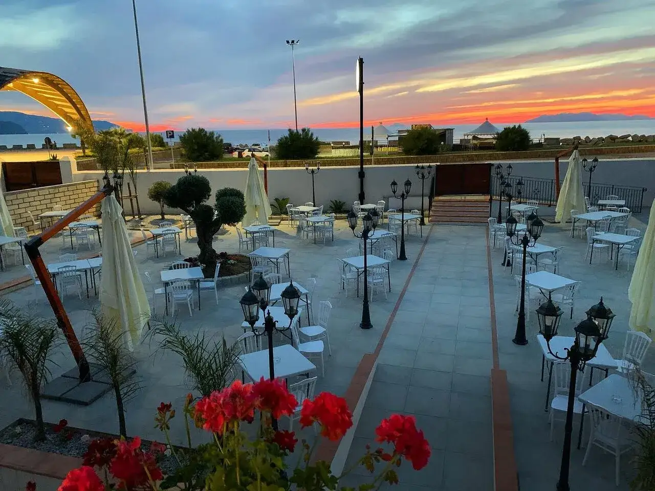 Terrazza con tavoli apparecchiati al tramonto, pronta per accogliere i clienti del vecchio palmento menu.