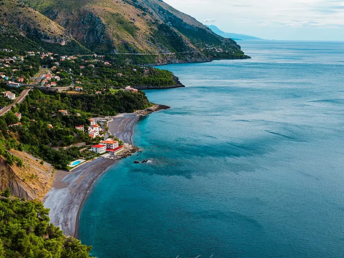 Costa del Basilicata on the road: un borgo aggrappato alla collina, una spiaggia scura e il blu intenso del mare.