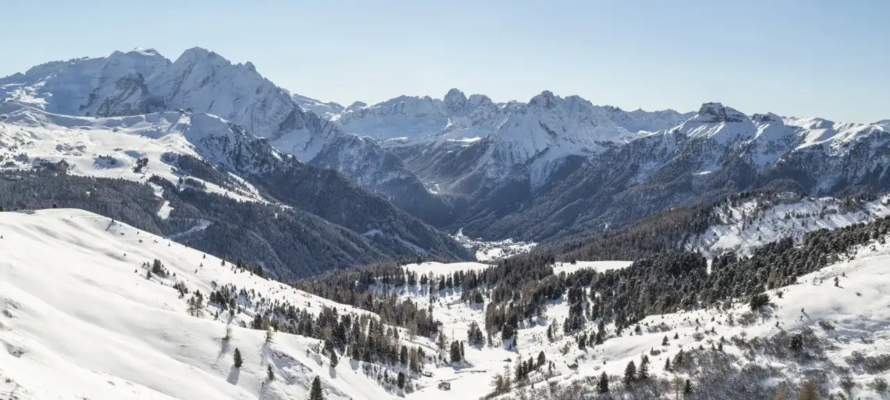 Panorami innevati delle Dolomiti, perfetti per scoprire cosa fare a Canazei tra sci e natura.