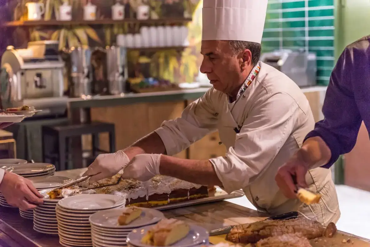 Chef serve una torta, forse una deliziosa azdora romagnola, a un buffet.