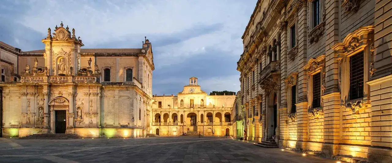 Piazza del Duomo illuminata di sera, un assaggio di cosa vedere a Lecce in un giorno: la Basilica e il Palazzo Vescovile.