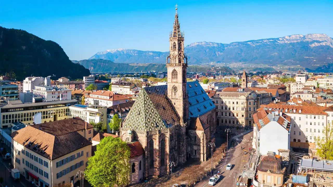 Vista aerea di Bolzano con il Duomo e le montagne sullo sfondo. Perfetto per scoprire cosa vedere a Bolzano in un giorno.