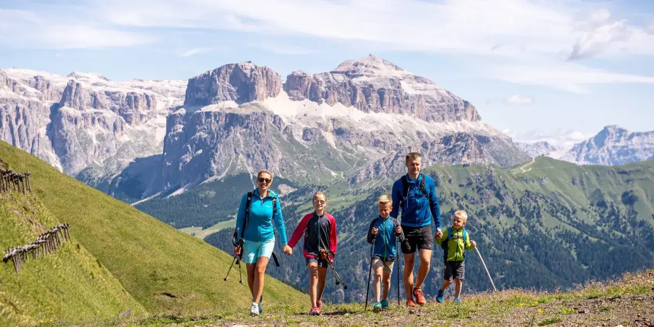 Famiglia in escursione tra le Dolomiti, un'ottima idea per cosa fare a Canazei.