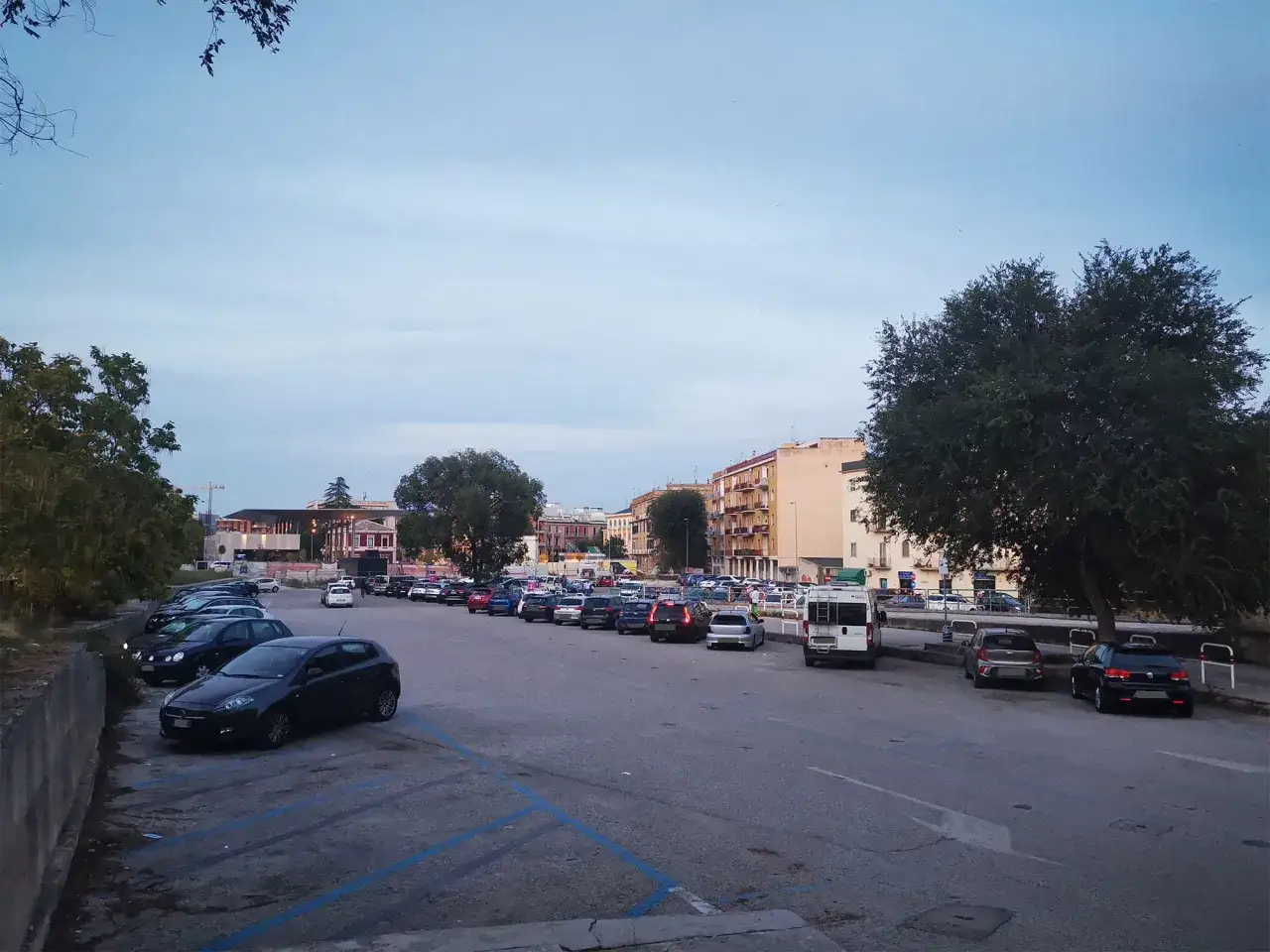 Ampio parcheggio con molte auto, ideale per chi cerca dove parcheggiare a Matera.