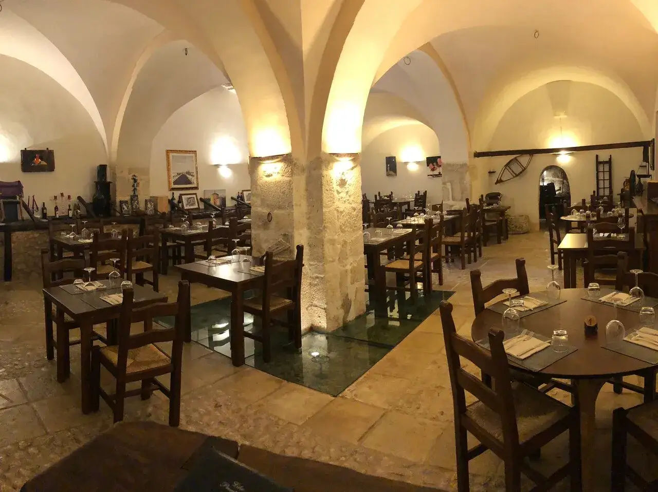 Interno di un ristorante con tavoli apparecchiati e volte in pietra, ideale per scoprire i migliori ristoranti di Santo Stefano di Sessanio.