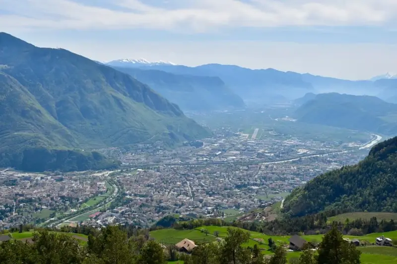 Vista panoramica di Bolzano e della valle, con montagne verdi e innevate sullo sfondo. Perfetto per scoprire cosa fare a Bolzano in un giorno.